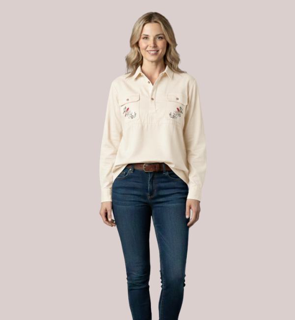 Model wearing a cream-beige long-sleeve customizable nursing shirt for women, featuring a quarter-button placket and twin custom floral embroidery patches on the front.