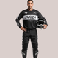 Man wearing a black and white Thrila Pro-Series long-sleeve motocross jersey and pants, customizable racewear kit, holding a black dirt bike helmet.
